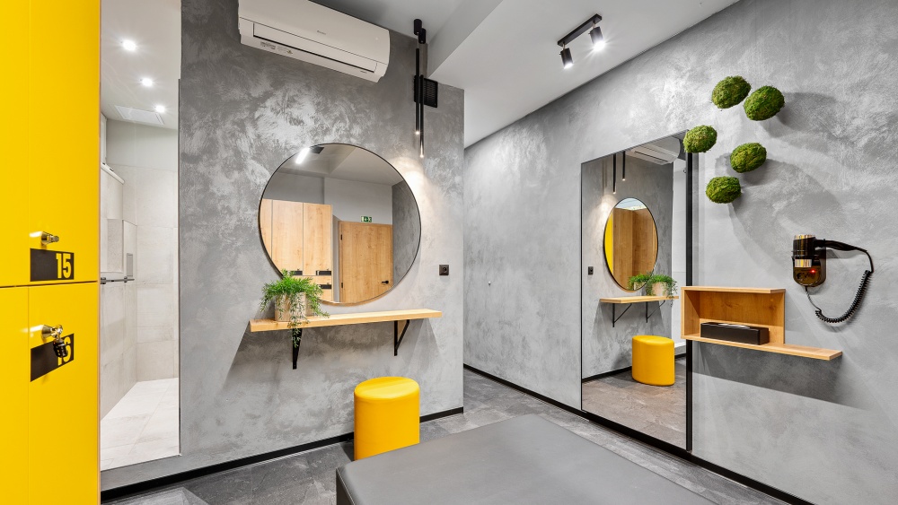 šatna. sprchy, kulaté zrcadlo, žlutá