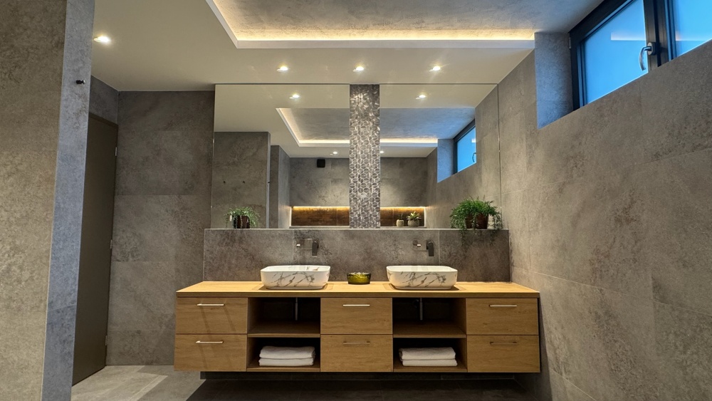 mramorové umyvadlo, dřevěné skříňky, kamenné kachličky